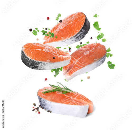 Fresh salmon steaks and spices falling on white background