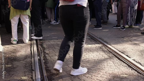 Low angle view of people's legs standing on street in a cue, people stand in a crowd meeteng