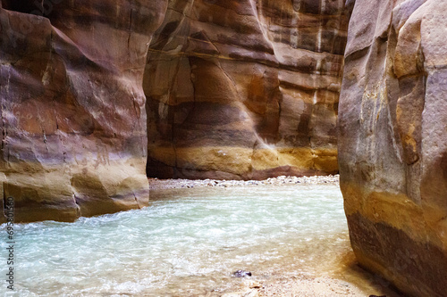 Jordan. Wadi Al Mujib Canyon in Wadi Mujib Nature Biosphere Reserve. Sheer cliffs of enormous height are polished by water ofWadi Mujib River, also known as Arnon Stream, flowing along bottom of gorge photo