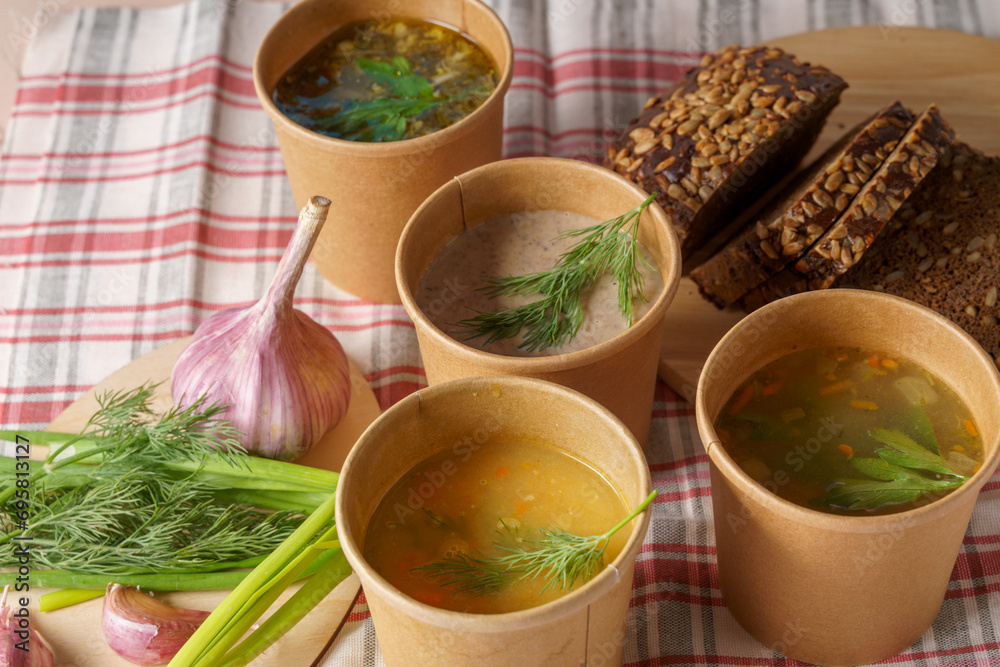 Pea,vegetable,chicken and mushroom soup in paper disposable cups for take-out or delivery of food,bread,garlic Pea,vegetable,chicken and mushroom soup in paper disposable cups for take-out or delivery of food,bread,garlic