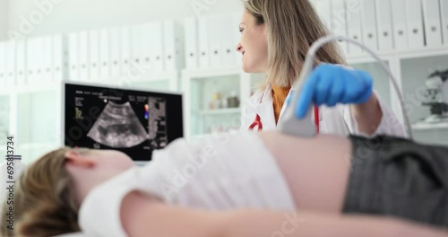 Doctor conducting ultrasound examination of internal organs of child in clinic. Diagnosis and treatment of diseases of liver and biliary tract in children photo