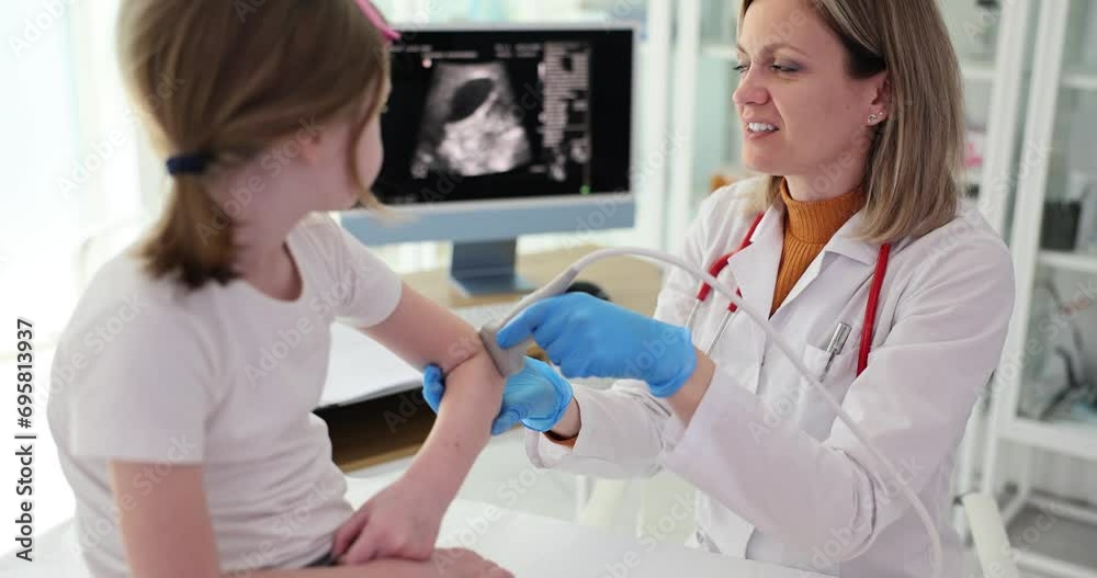 Doctor sonologist conducts an ultrasound examination of elbows of little girl in clinic. Elbow pain causes and diagnosis Doctor sonologist conducts an ultrasound examination of elbows of little girl in clinic. Elbow pain causes and diagnosis