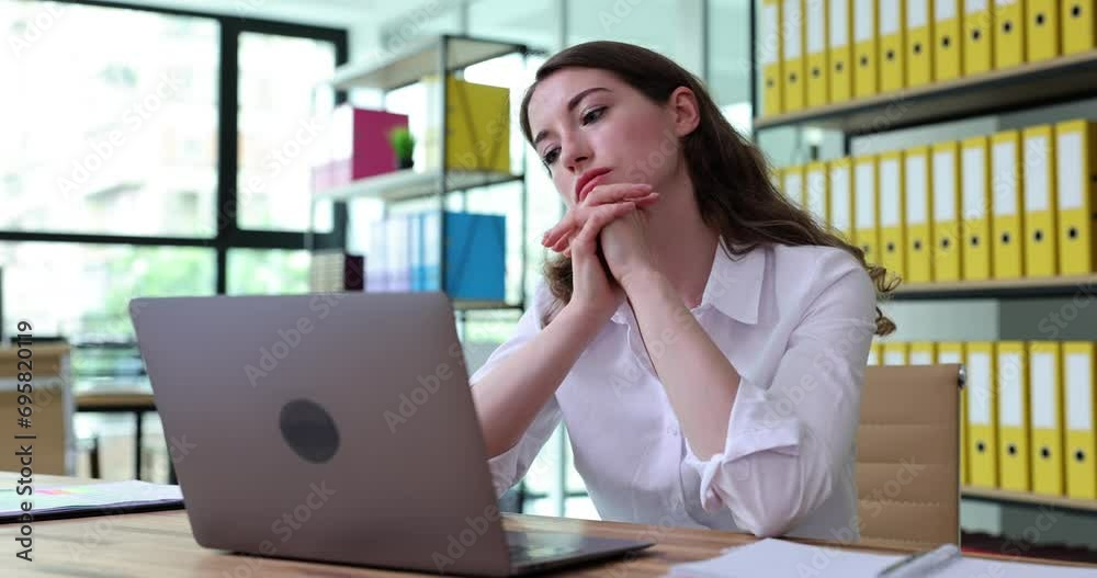 Worried puzzled woman looking at laptop in office and feeling stressed. Businesswoman frustrated due to problem with computer software Worried puzzled woman looking at laptop in office and feeling stressed. Businesswoman frustrated due to problem with computer software