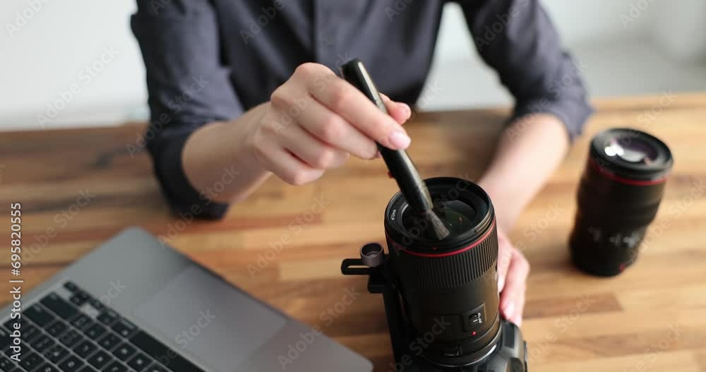 Cleaning lens of digital camera from dust with special pen for cleaning lenses. Care of photographic equipment and cleaning camera lens