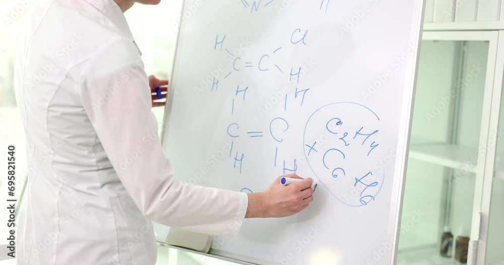 Woman scientist drawing chemical formulas on board. Chemistry research and science education Woman scientist drawing chemical formulas on board. Chemistry research and science education
