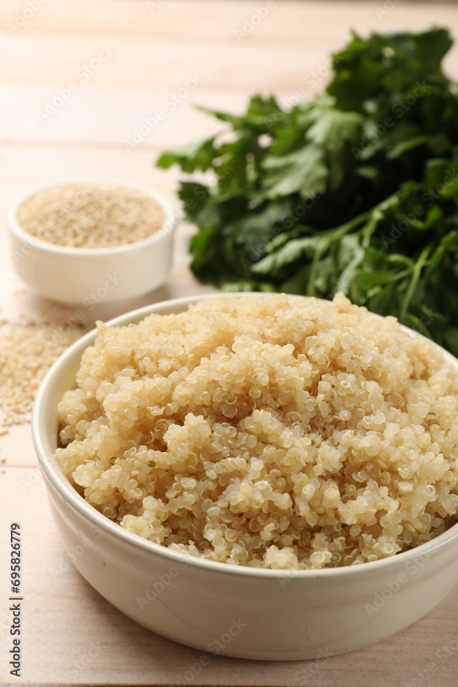 Tasty quinoa porridge in bowl on light wooden table, closeup Tasty quinoa porridge in bowl on light wooden table, closeup