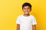 Indian boy smiling at camera on yellow background