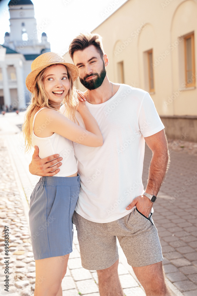 Naklejka premium Smiling beautiful woman and her handsome boyfriend. Woman in casual summer clothes. Happy cheerful family. Female having fun. Couple posing in street at sunny day. Having tender moments. In hat