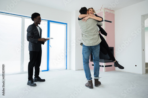 African american young real estate just sold a house to a happy young amily. Real estate concept good investment in the future happy ownership delighted wife and woman hugging in new house. photo