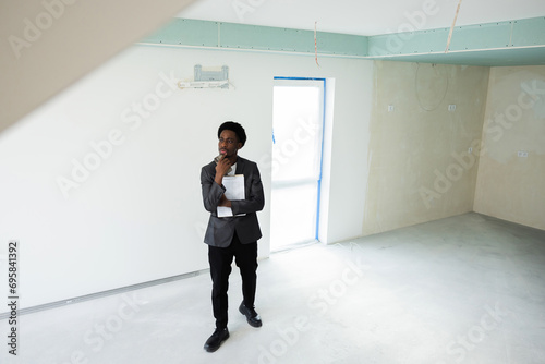 Serious smart clever busy african american dark skinned buisnessman wearing smart casual outfit suit calling someone talking on phone with customers clients. Real estate agent waits for clients.
