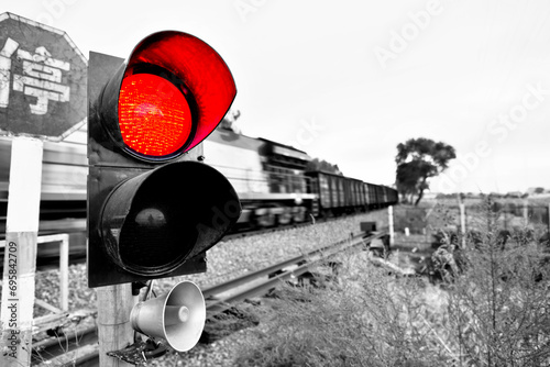 Chinese characters stop and traffic light shows red signal next to railway © xy
