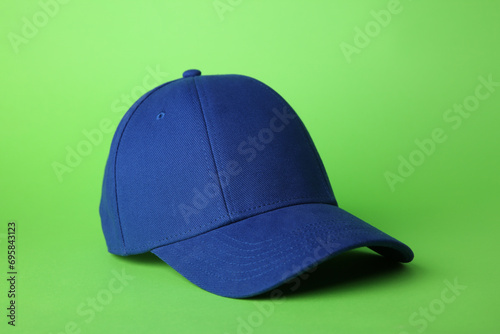 Stylish blue baseball cap on light green background