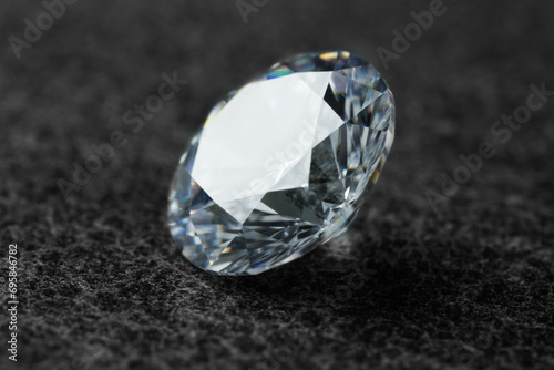 Beautiful shiny diamond on dark grey background  closeup