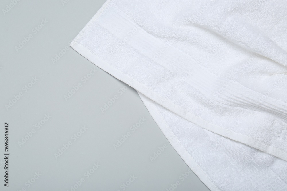 White terry towel on light grey background, top view. Space for text White terry towel on light grey background, top view. Space for text