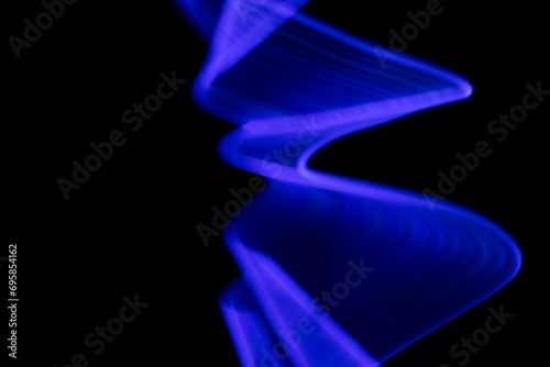 Abstract neon background with copy space. Blue light waves on a black. Freeze light, long exposure