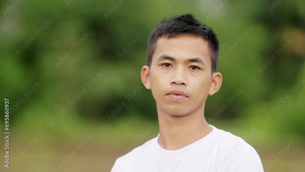 Portrait of young Asian farmer, serious and focused, in rural agricultural setting Portrait of young Asian farmer, serious and focused, in rural agricultural setting