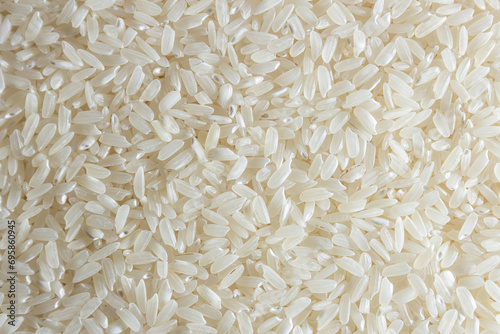 Dry Uncooked White Rice Background - Top View, Flat Lay. Scattered Raw Long Grain Rice. Asian Cuisine and Culture. Healthy Eating Ingredients. Diet Food