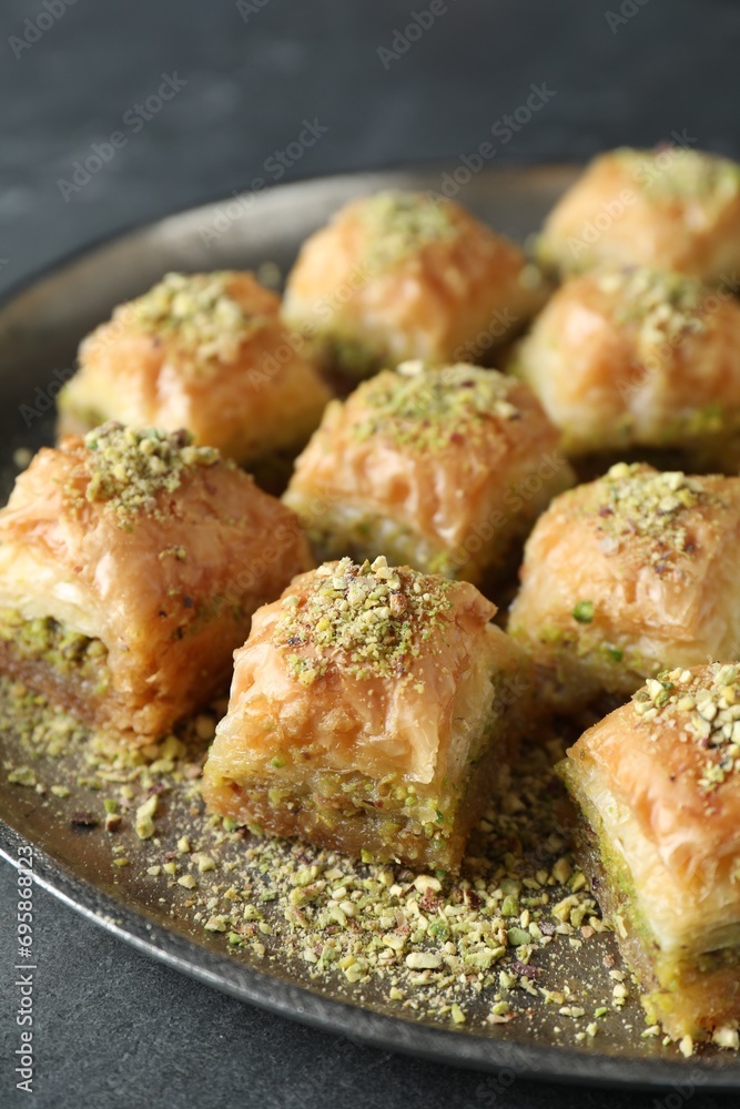 Delicious fresh baklava with chopped nuts on grey table, closeup. Eastern sweets