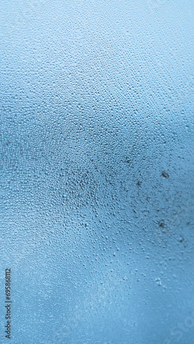 Condensation on window glass in frosty winter weather. Background in the form of small drops on the glass.