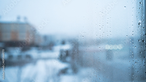 Condensation on the window in frosty weather. Small drops on the glass. New Year's opening. Frosty pattern
