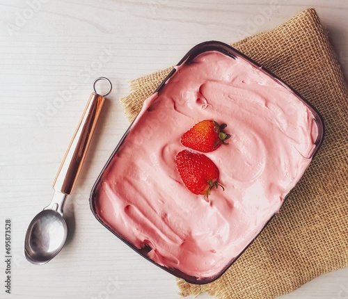 scoop of strawberry ice cream in jar on blurred background photo