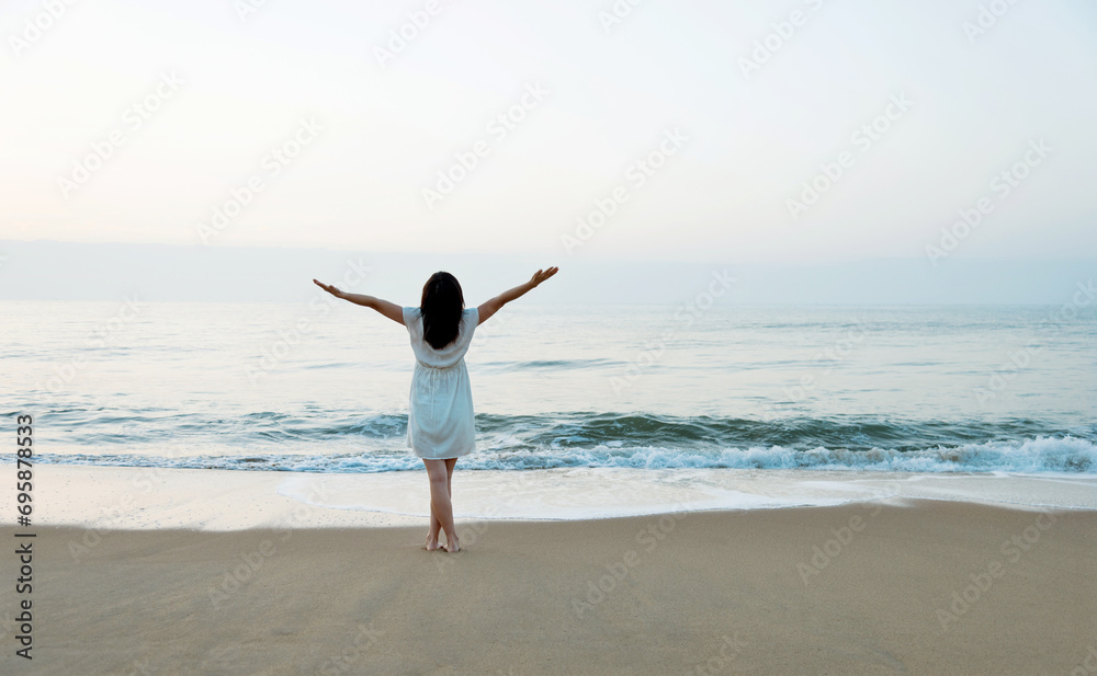 Happy woman standing on the beach with hands up. Happy woman standing on the beach with hands up.