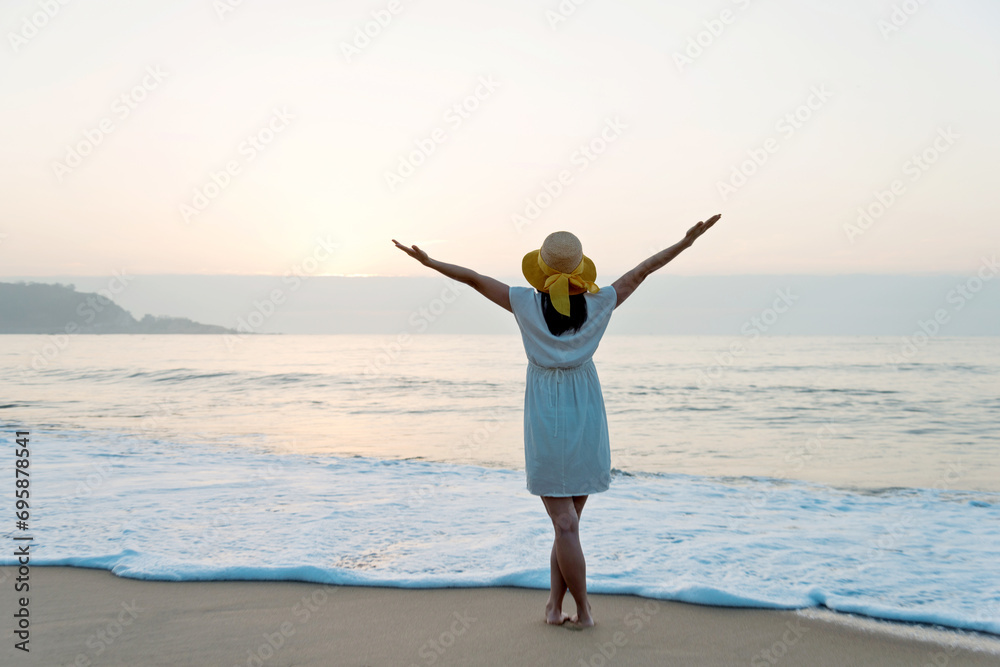Happy woman standing on the beach with hands up. Happy woman standing on the beach with hands up.
