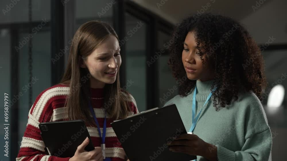 African American trainee with an afro and a Caucasian colleague in an office, both looking stressed, possibly due to overtime work. African American trainee with an afro and a Caucasian colleague in an office, both looking stressed, possibly due to overtime work.