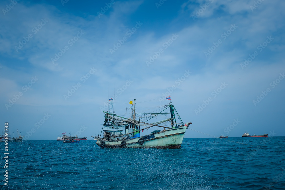 Obraz premium Wooden fishing boat on the sea. Fishing industry in Thailand. Sattahip, Chonburi, Thailand. Fishing industry in Thailand