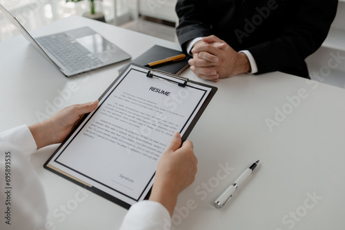 Woman candidate interview with HR manager in office, Examiner reading a resume during job interview at office Business and human resources concept, Close up view of job interview in office,