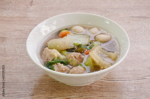 boiled chop pork with fish ball couple cabbage topping seaweed in clear soup on bowl