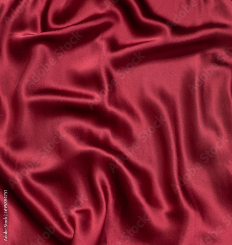 Natural magenta red silk fabric with folds texture close up