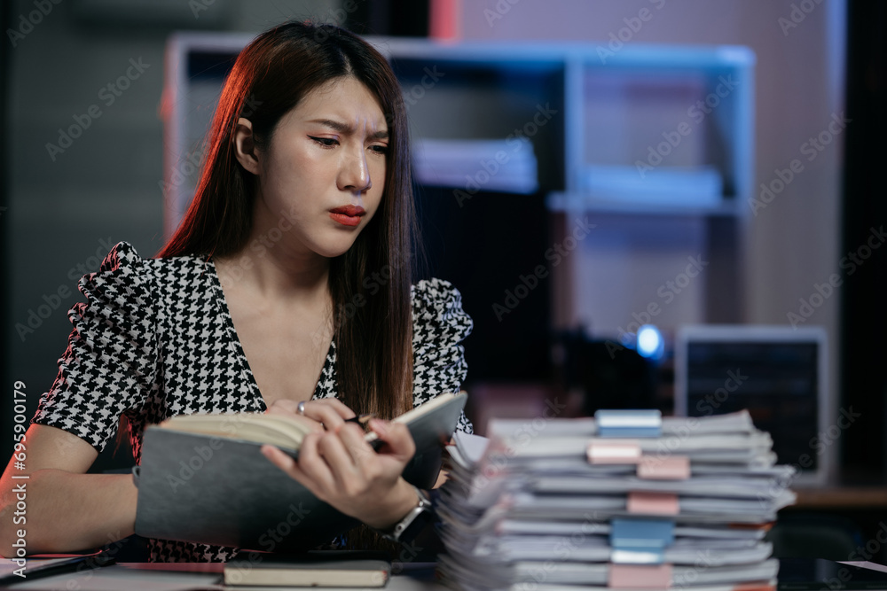 Fototapeta premium Serious businesswoman concentrating on his paper work at the table at office.