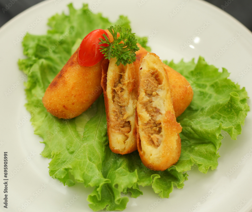 Home made potato and tuna fish croquette. Italian oven baked potato ovals with curry, tuna fish and fresh parsley and tomato. Selective focus.
Home made potato and tuna fish croquette. Italian oven baked potato ovals with curry, tuna fish and fresh parsley and tomato. Selective focus.