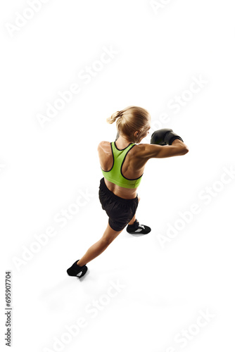 Left hook punch. Sportive young woman, boxing athlete with muscular body training isolated on white background. Top view. Concept of sport, active and healthy lifestyle, strength, endurance, body care