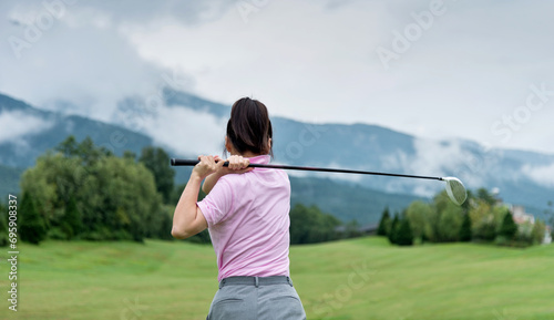 Woman golf player swinging golf club