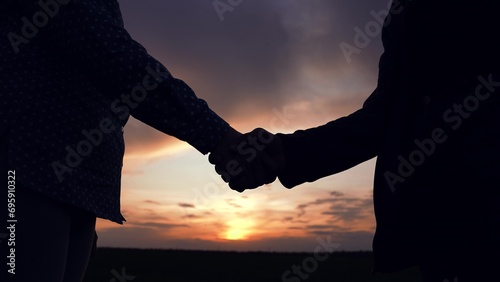 Business people shake hands outdoor. Two businessmen shaking hands signed contract. Conclusion of deal, Handshake agreed. Business through handshake. Hand silhouette. Greetings, sky. Trust partner