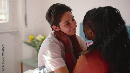 In the bedroom a couple of multi-ethnic girls hug and cuddle.
The two cute lesbian girls talk and have fun together.
Concept of diversity, love, and valentine's day photo