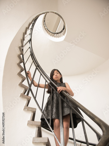 art portrait of girl in dress in spiral staircase photo