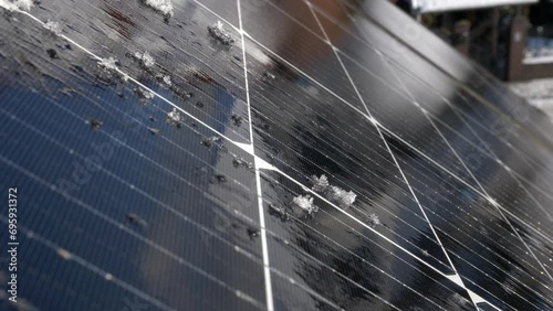 Snow Melting on PV Solar Panels Located on Private House Roof on Sunny Day