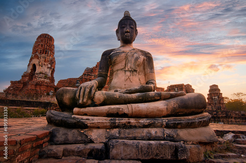 Ancient stone Budha statue in Khmer temple in Ayutthaya, Thailand on sunset
