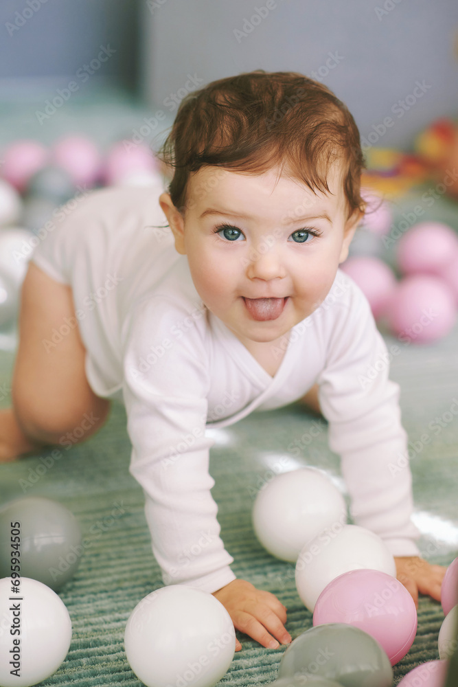 Adorable baby girl playing with mini ball pit, fun and activities for little kids Adorable baby girl playing with mini ball pit, fun and activities for little kids