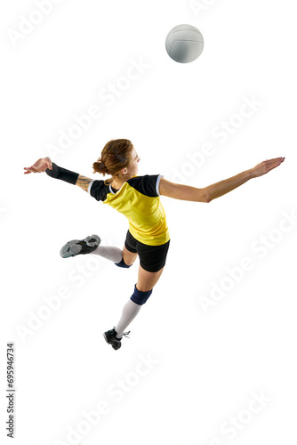 Young woman, professional volleyball player in yellow black uniform training, hitting ball in a jump isolated on white background. Concept of sport, competition, active and healthy lifestyle. Top view
