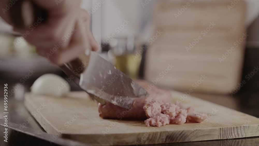 Pessoa cortando linguica em uma tabua. Churrasco. Closeup na mao.