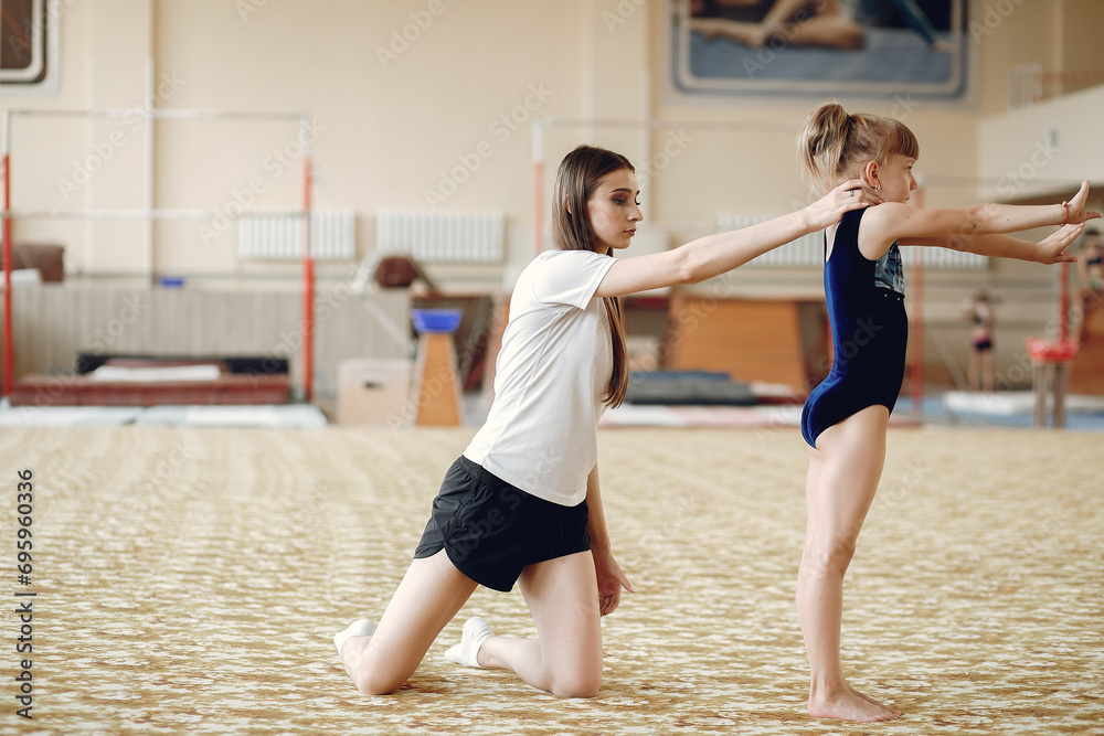 Fototapeta premium Lovely little girls gymnasts training in a athletics class