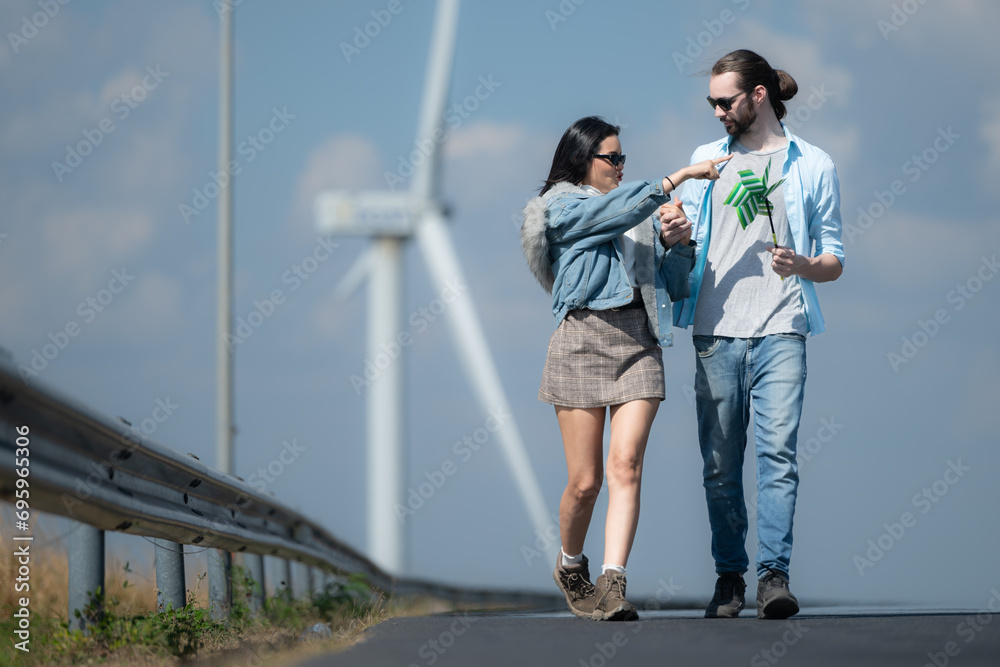 Young couple relaxing by the wind turbine on the lake Young couple relaxing by the wind turbine on the lake