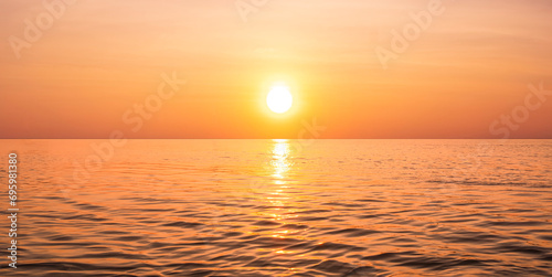 Beautiful orange sunrise sky background over sea with yellow sunlight reflection on sea surface in golden hour time  panoramic view
