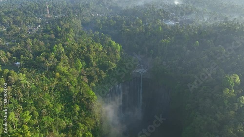 Aerial view of Tumpak Sevu Waterfall in the morning with sunlight. And with Gunung Semeru Volcano photo