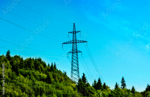 electricity transmission pylon silhouetted against blue sky