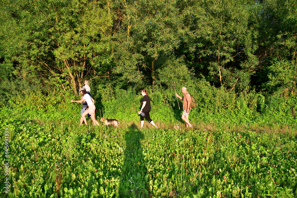 Tourists walk on the meadow in the summer to the nature for camping